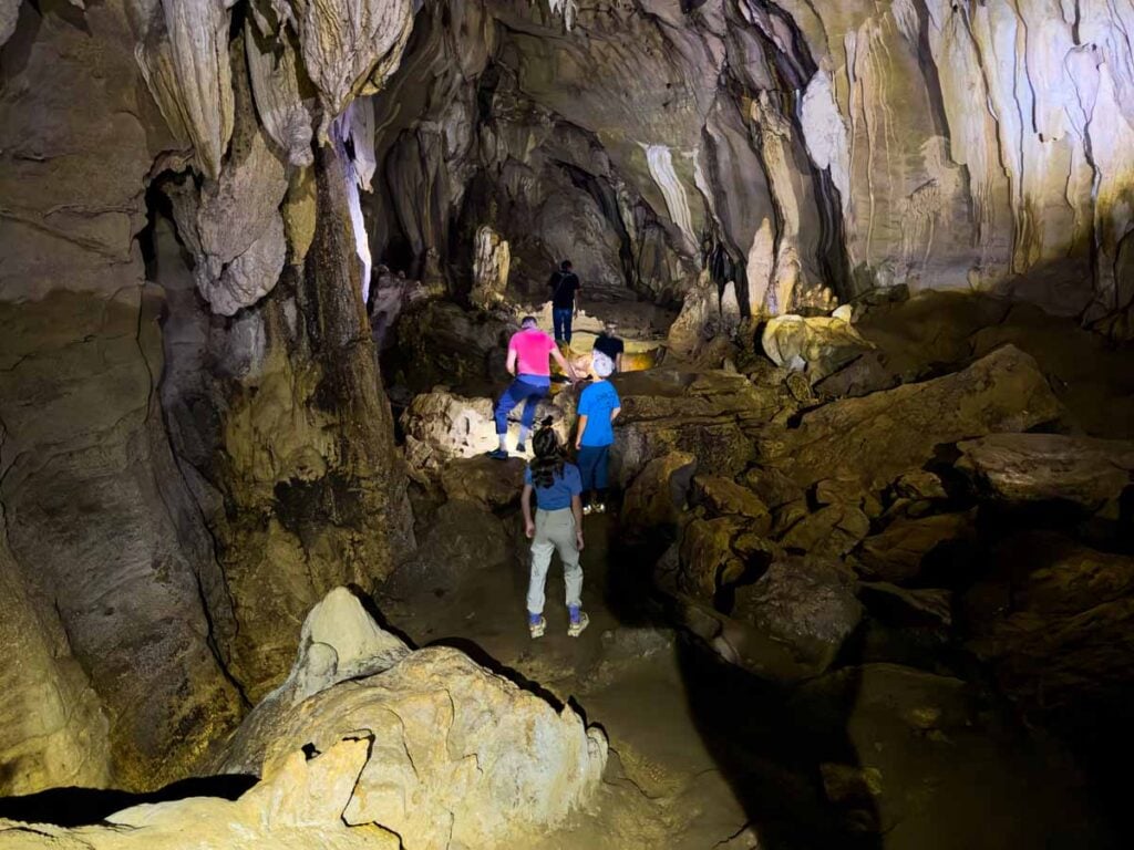 The Brewer kids, from the Family Can Travel blog, use head lamps to navigate the Bukit Lawang bat cave.