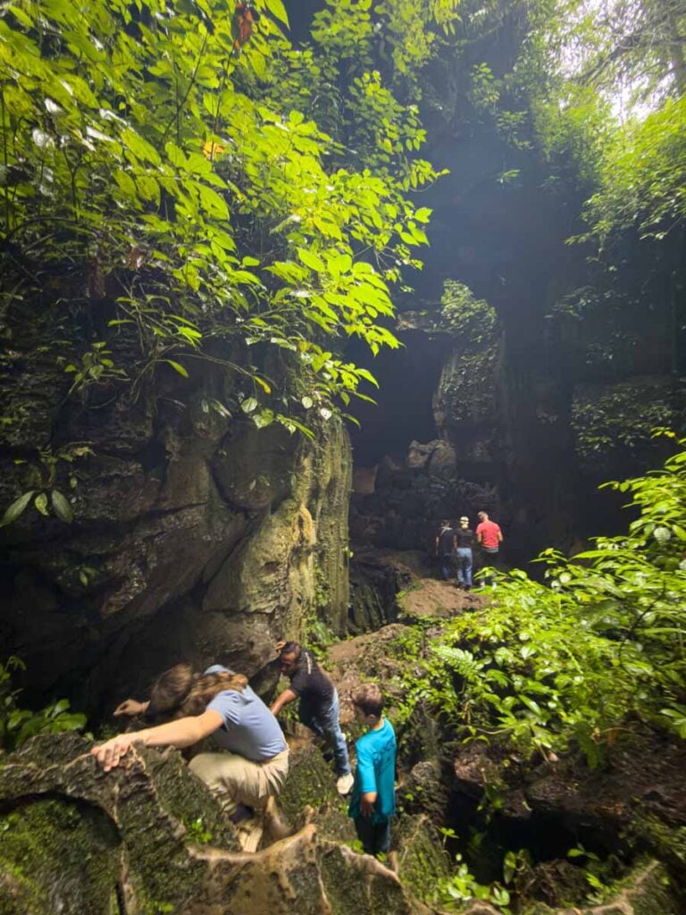 The Brewer kids climb down some rocks on the Bat Cave tour near Bukit Lawang.
