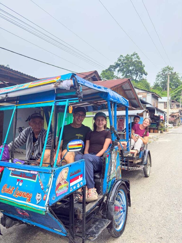 The Brewer family, from FamilyCanTravel.com, sit in tuk tuks on their way to the Bukit Lawang Friday market.