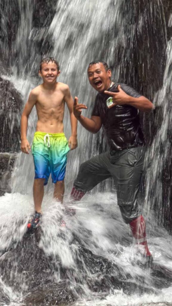 A Brewer child stands in a waterfall in Gunung Leuser National Park during a family trip to Bukit Lawang.