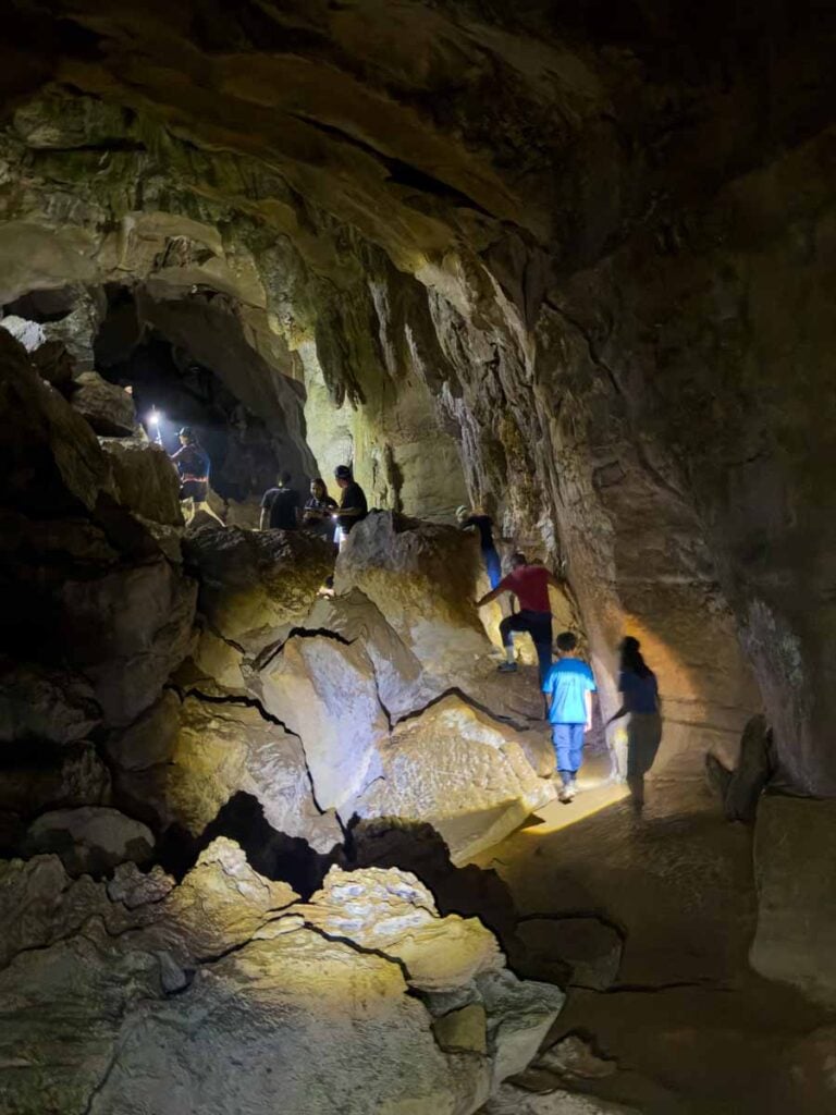 A Brewer child explores a large chamber in the bat cave near Bukit Lawang, Indonesia.