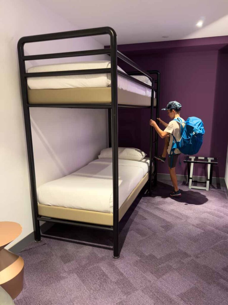 A Brewer child climbs the bunk bed in a Family Cabin at the YOTELAIR Singapore Changi Airport Hotel.