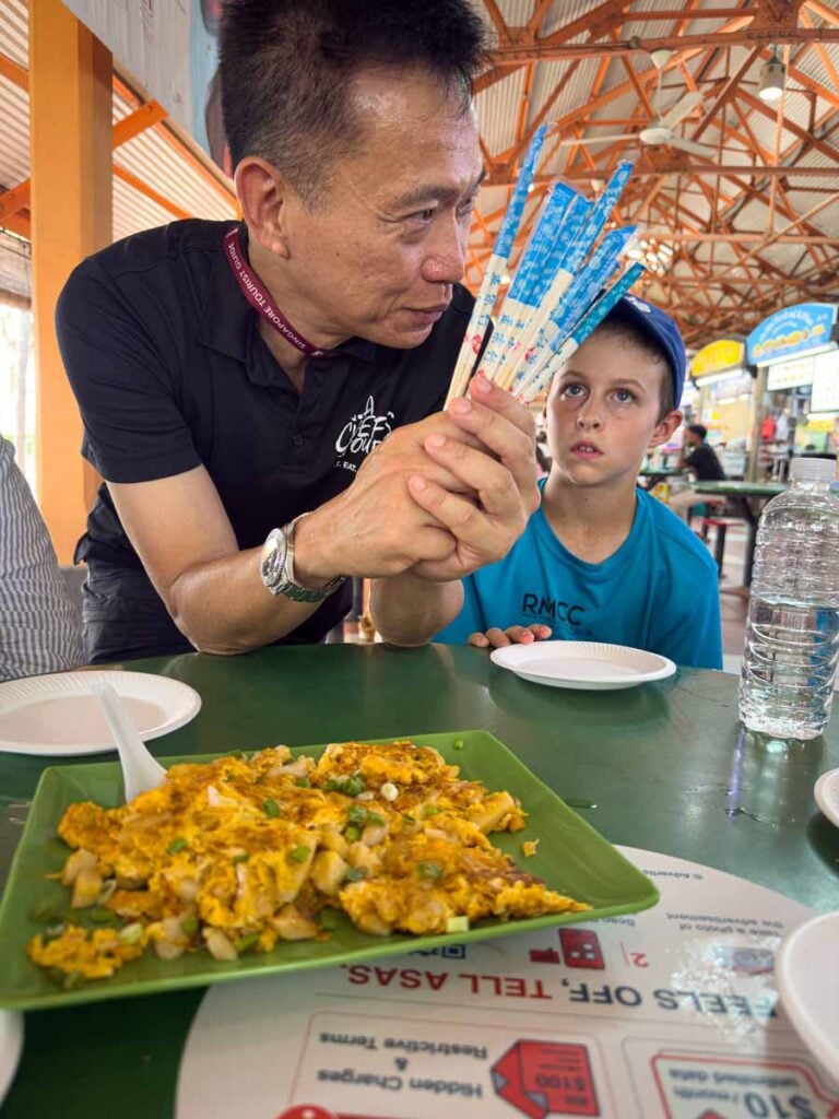 Our guide explains what we are about to eat on our kid-friendly food tour in Singapore.