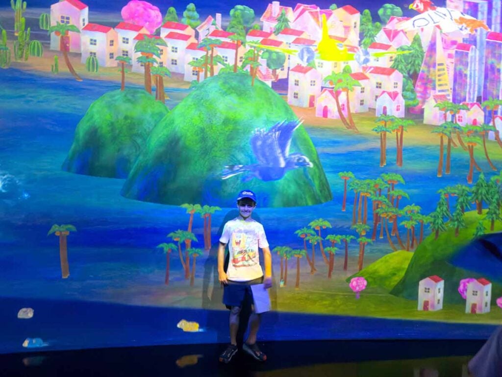 One of the Brewer kids stands by his artwork which came to life on a giant screen at the Future World exhibit at the ArtScience Museum in Singapore.