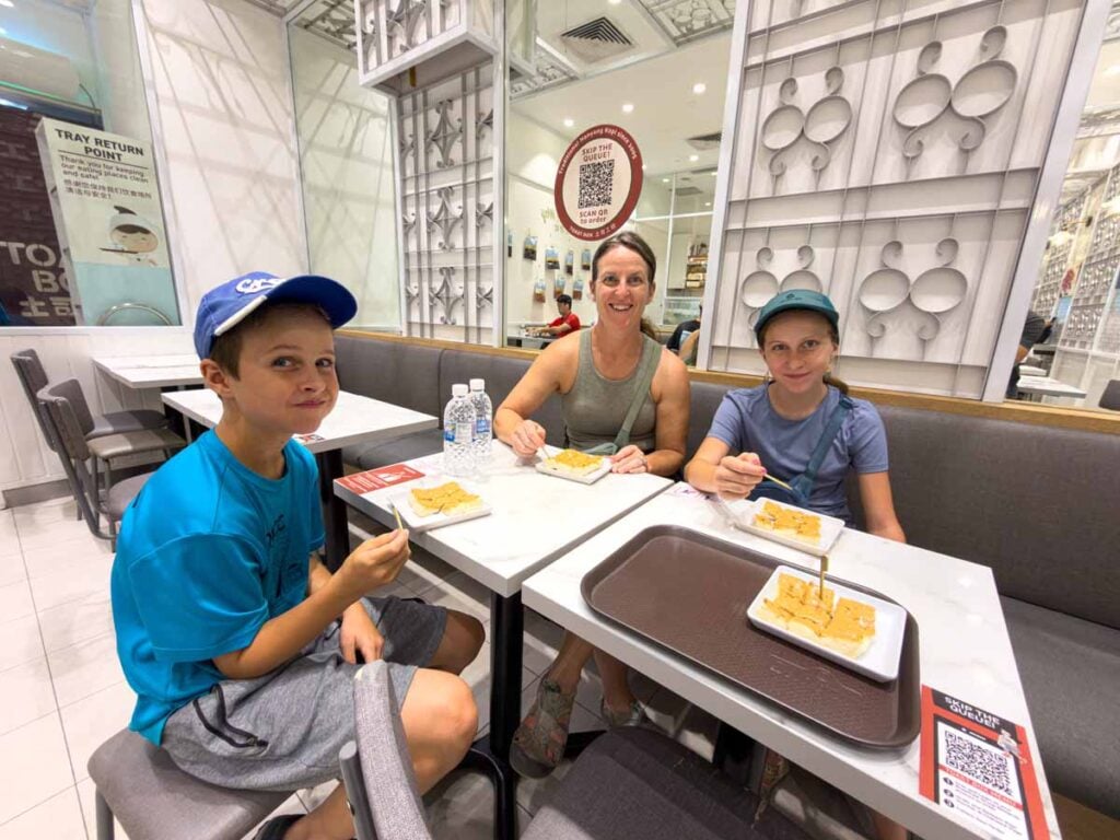 Celine Brewer, owner of FamilyCanTravel.com, eats at Toast Box with her kids during a family trip to Singapore.