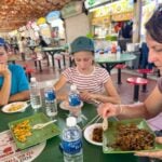 Things to do in Singapore with Kids - Food Tour - Maxwell Food Centre Celine Brewer, owner of FamilyCanTravel.com, serves up dishes we got to try on our food tour at Maxwell Food Centre.