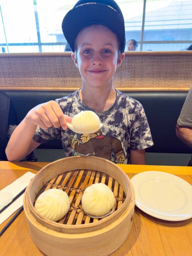 One of the Brewer kids eats pork steamed bins at the Din Tai Fung restaurant in Sentosa, Singapore.