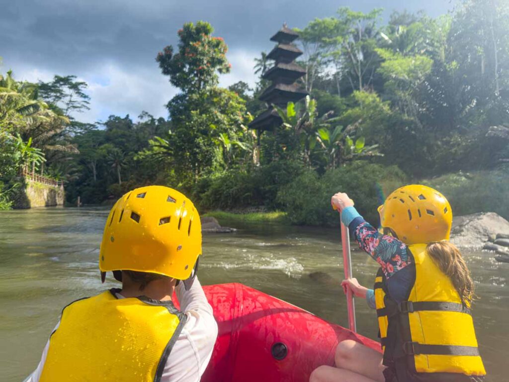 The Brewer kids paddle past a temple during a family-friendly white water rafting tour in Bali.
