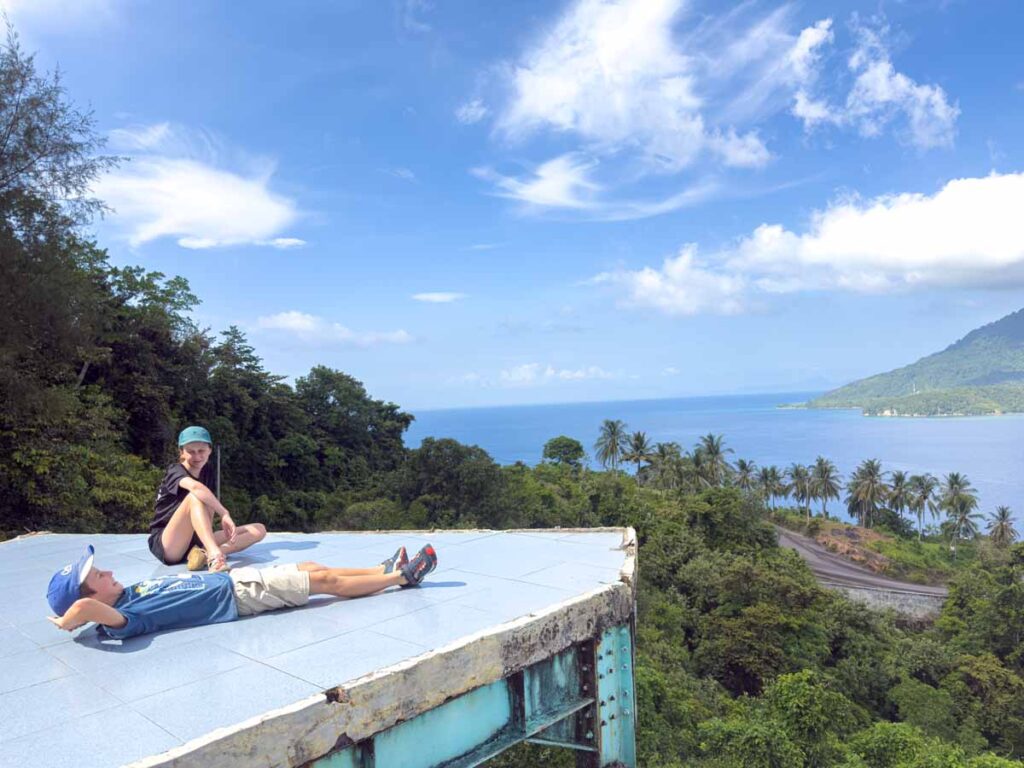 The Brewer kids rest on a viewing platform over Balohan harbour while on a family-friendly tour of Pulau Weh.
