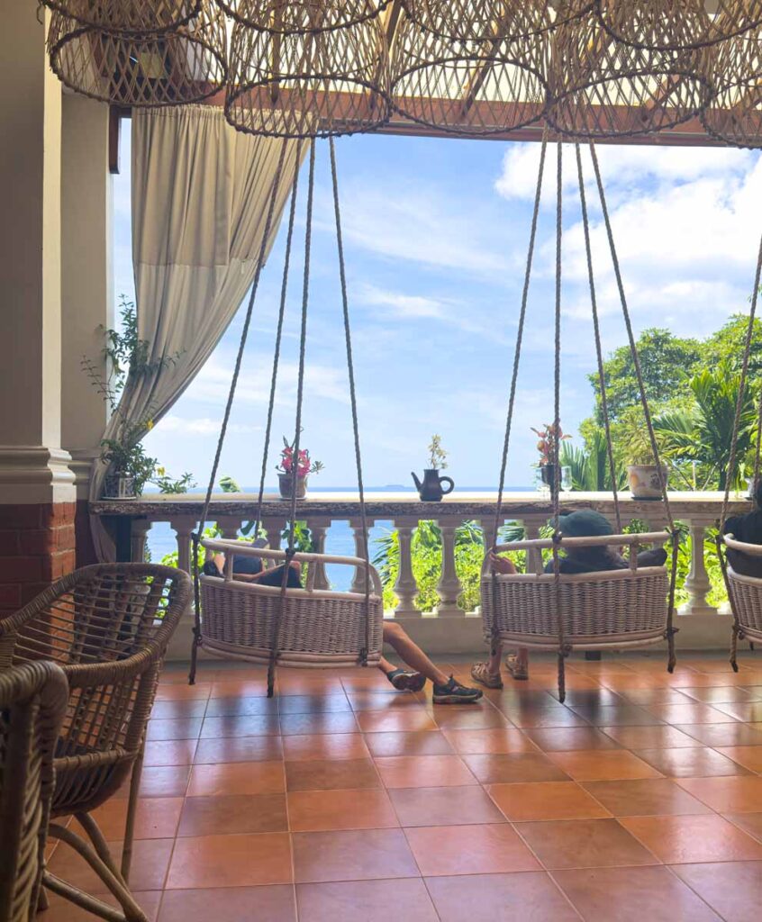 The Brewer kids swing on chairs with a view at the Aceh Heritage Village, our favourite kid-friendly restaurant in Pulau Weh.