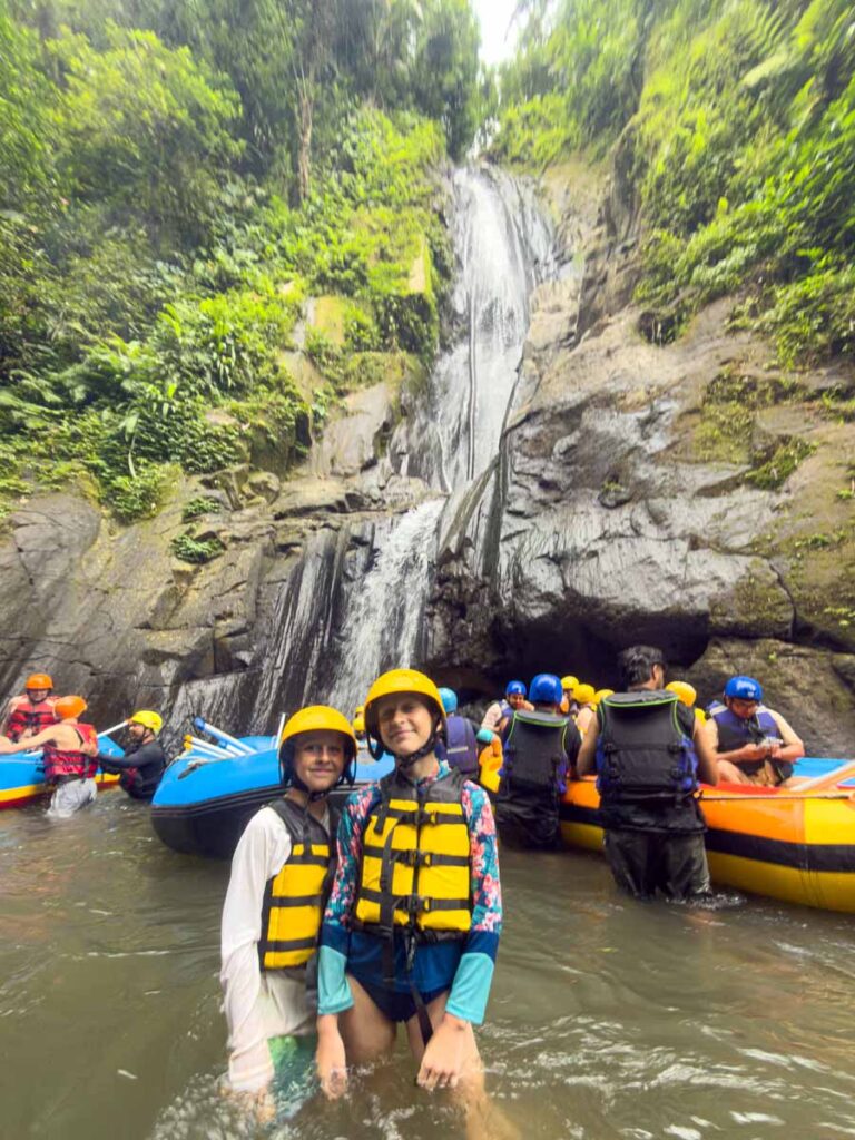 The Brewer kids in front of a tall waterfall on a white water rafting tour in Bali.
